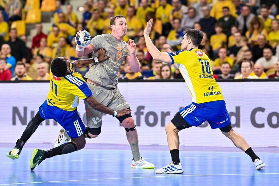 Kielce's Benoit Kounkoud and Alex Dujshebaev try to stop Aalborg's Sander Sagosen  