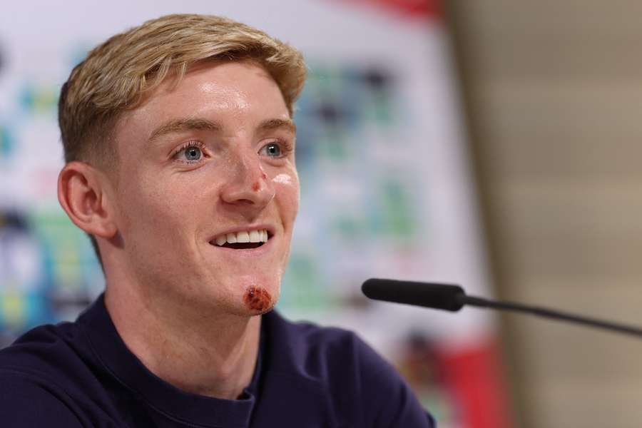 England forward Anthony Gordon speaks during a press conference bearing the scars of a bicycle accident