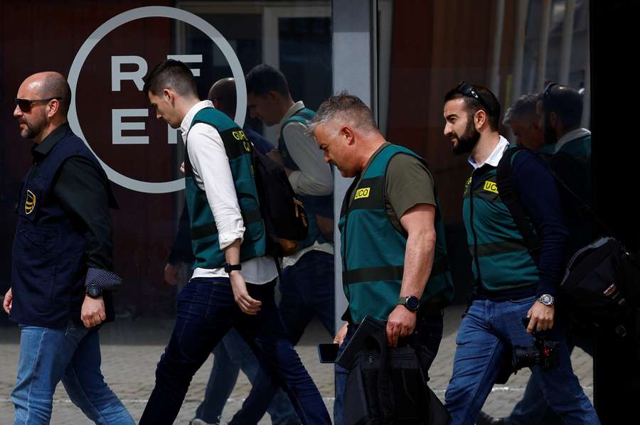 Three Spanish Civil Guards and one Europol officer walk out of the RFEF headquarters