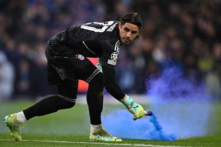 Bayern Munich's Swiss goalkeeper Yann Sommer throws a smoke bomb from his goalmouth