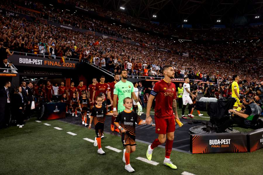 Roma and Sevilla players walk onto the pitch ahead of the match