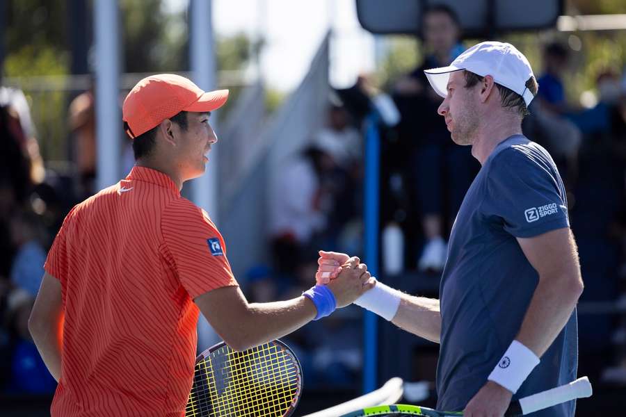 Botic van de Zandschulp and Juncheng Shang shake hands after their Australian Open match