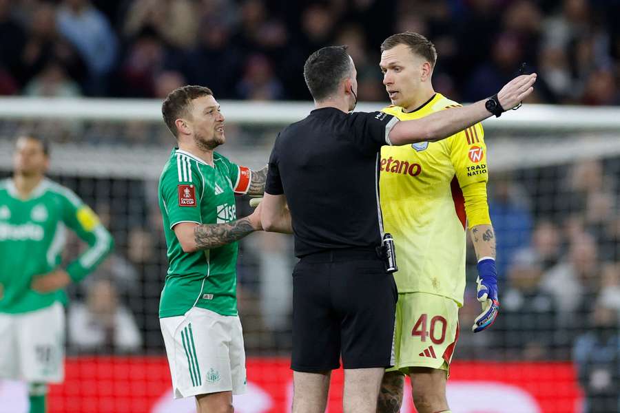 Chris Kavanagh tells Aston Villa's Marco Bizot to leave the pitch after he was shown a red card