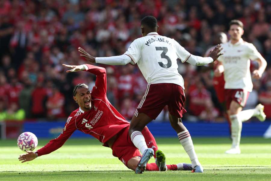 Liverpool's Hugo Ekitike goes down in a challenge with Arsenal defender Christhian Mosquera