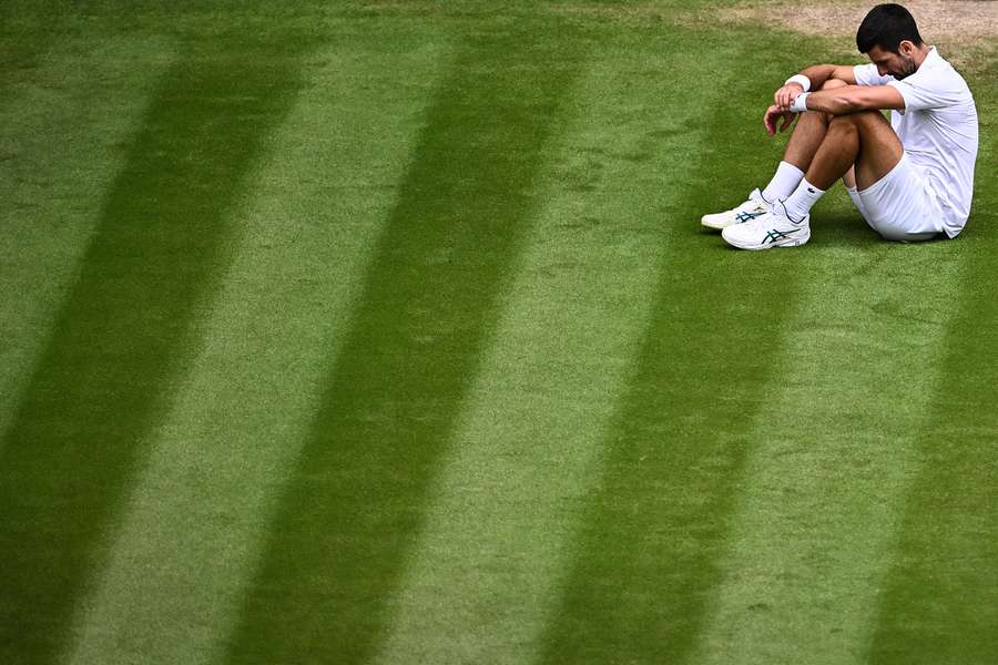 Djokovic, sentado depois de uma queda na relva do Centre Court