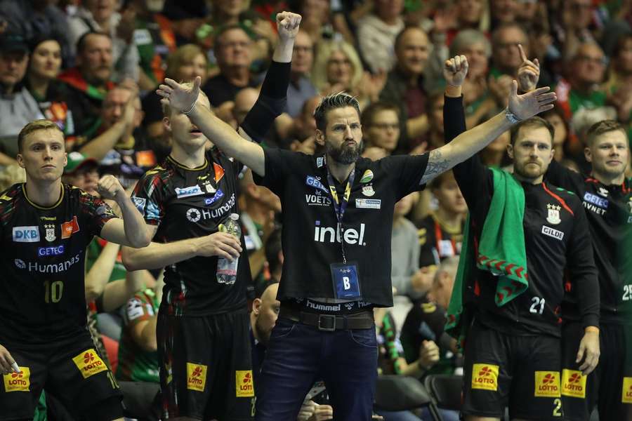 Magdeburg-Coach Wiegert (m.) darf mit seinem Team weiterjubeln Magdeburg-Coach Wiegert (m.) darf mit seinem Team weiterjubeln