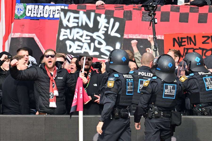 Polizeieinheiten kümmern sich um Nürnberger Fans, die aus Protestzwecken den Innenraum gestürmt haben.