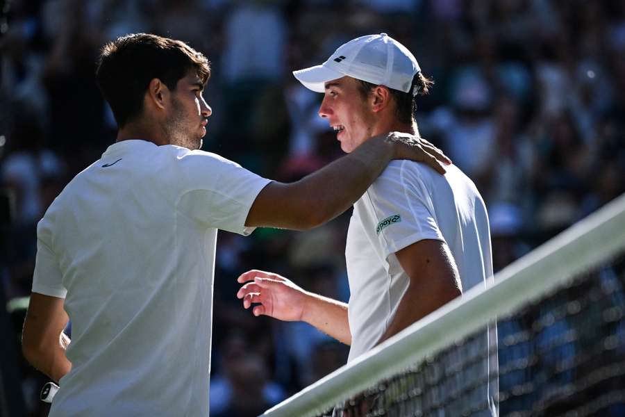 Spain's Carlos Alcaraz (L) congratulates Britain's Oliver Tarvet at the end of their men's singles second round tennis match