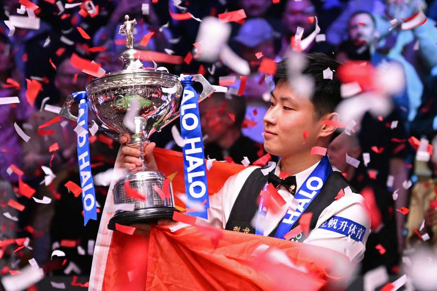China's Zhao Xintong poses with the trophy after victory over Wales' Mark Williams