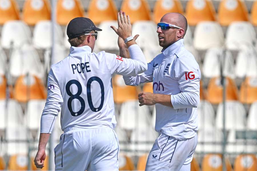 England's Jack Leach (R) celebrates with his captain Ollie Pope after taking the wicket of Pakistan's Salman Agha