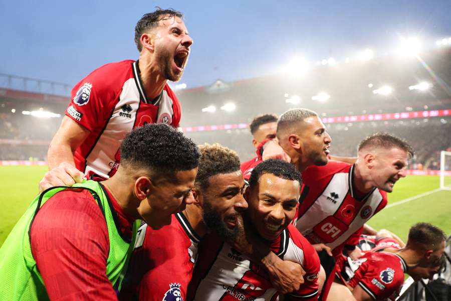 Sheffield United celebrate scoring in the final moments against Wolves as they won their first Premier League match of the season