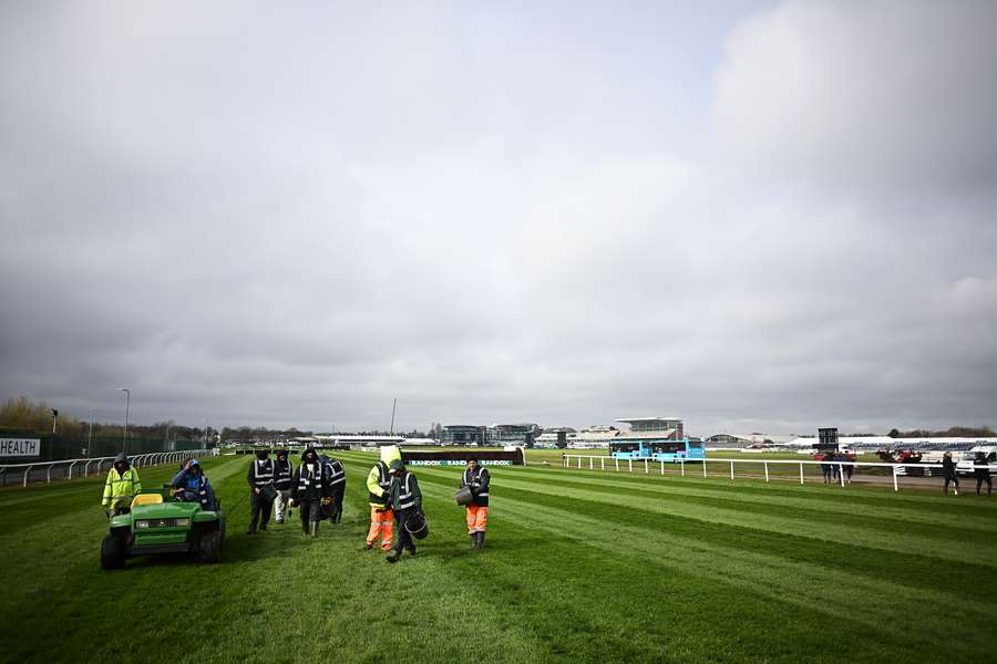 Groundstaff check the course on the second day of the Grand National Festival horse race meeting at Aintree Racecourse