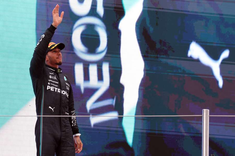 Mercedes driver Lewis Hamilton waves on the podium as he celebrates his second place after the Spanish Grand Prix