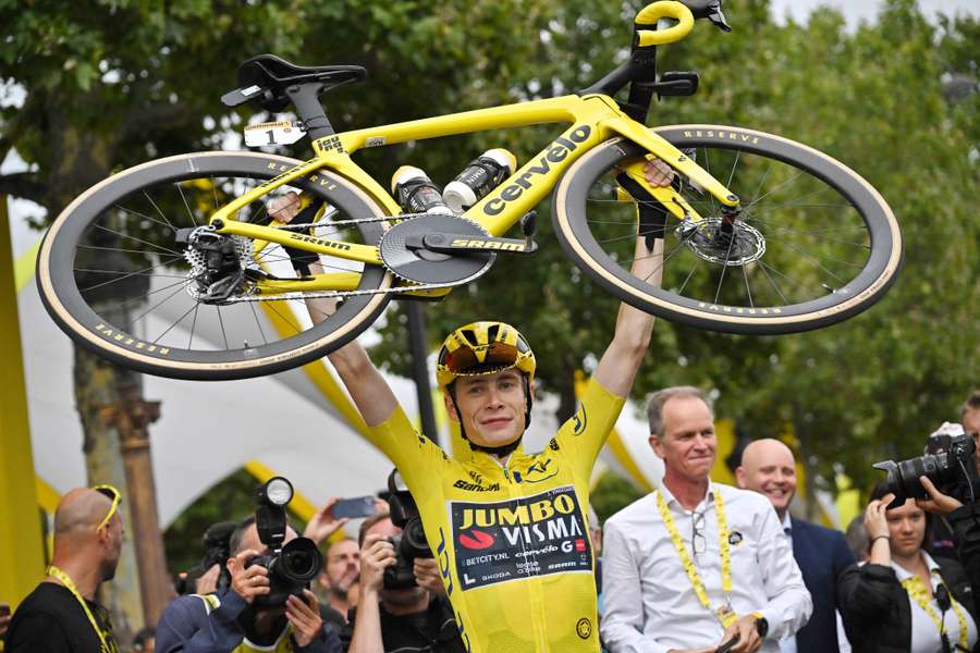 Jonas Vingegaard lifts his bike as he celebrates winning the Tour de France 