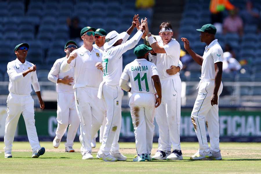 Gerald Coetzee is surrounded by his teammates after picking up a wicket