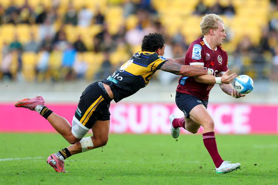 Tom Lynagh attempts to evade Hurricanes rival Billy Proctor. Tom Lynagh attempts to evade Hurricanes rival Billy Proctor.
