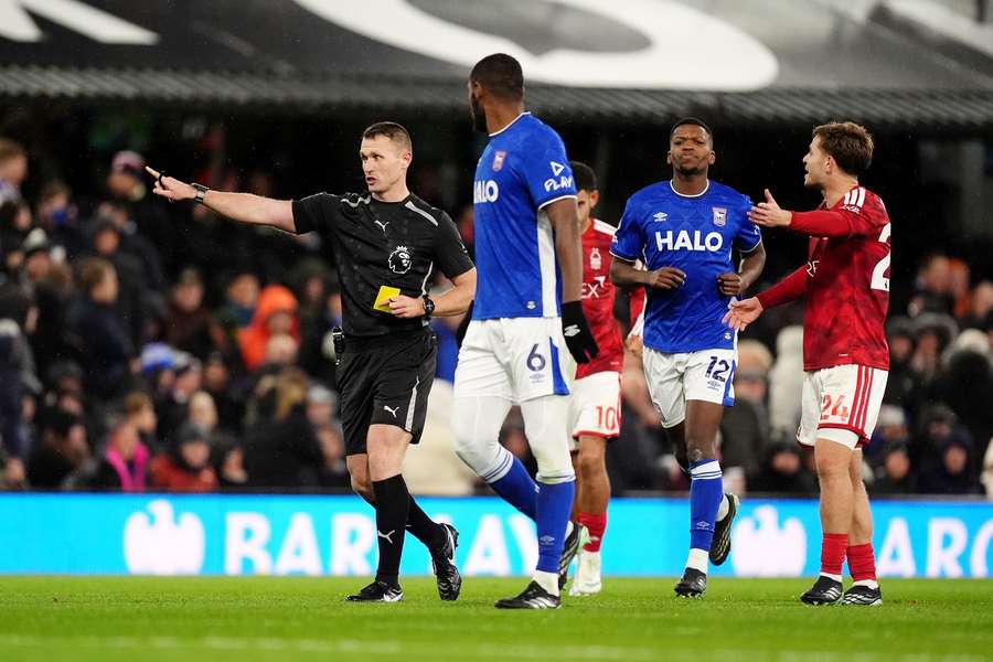 Referee Thomas Bramall (left) shows a yellow card to Ipswich Town's Issa Diop after a VAR check.