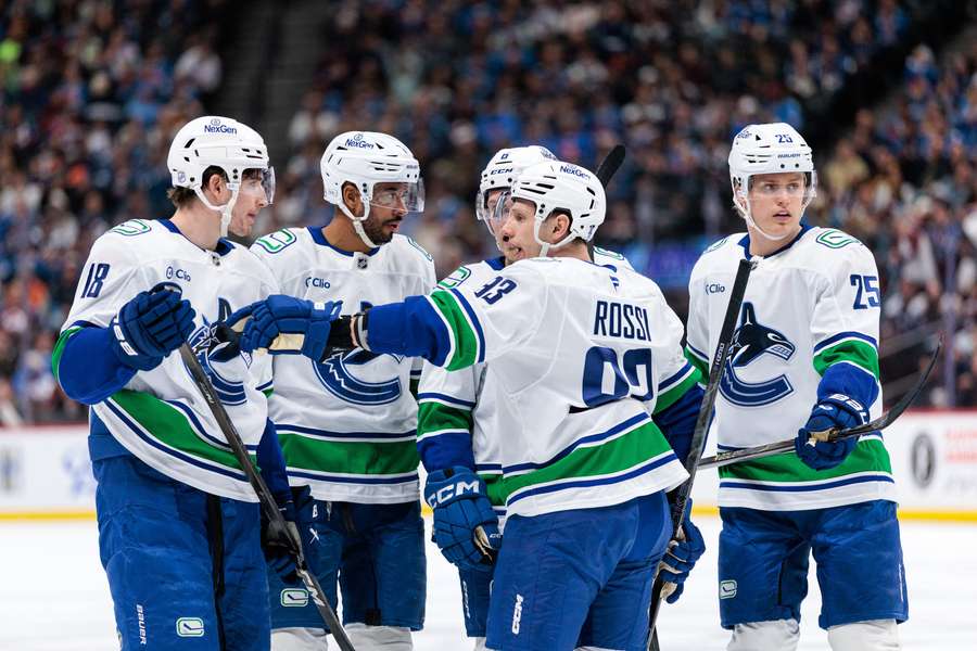 Canucks players talk during Avalanche matchup