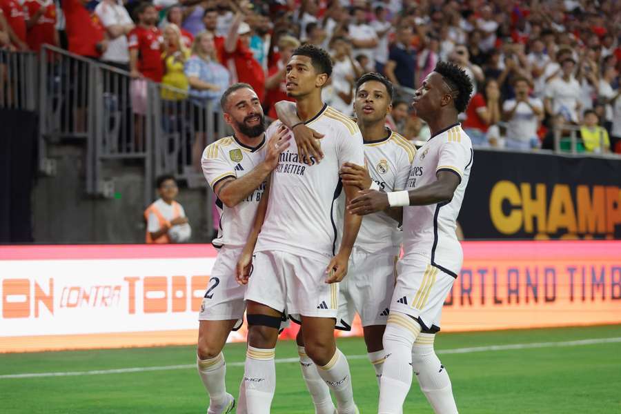 Jude Bellingham wordt gefeliciteerd door zijn teamgenoten na het scoren van zijn eerste Real-doelpunt