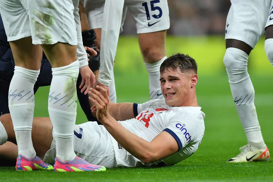 Micky van de Ven ligt geblesseerd op het gras tijdens Tottenham Hotspur - Chelsea FC