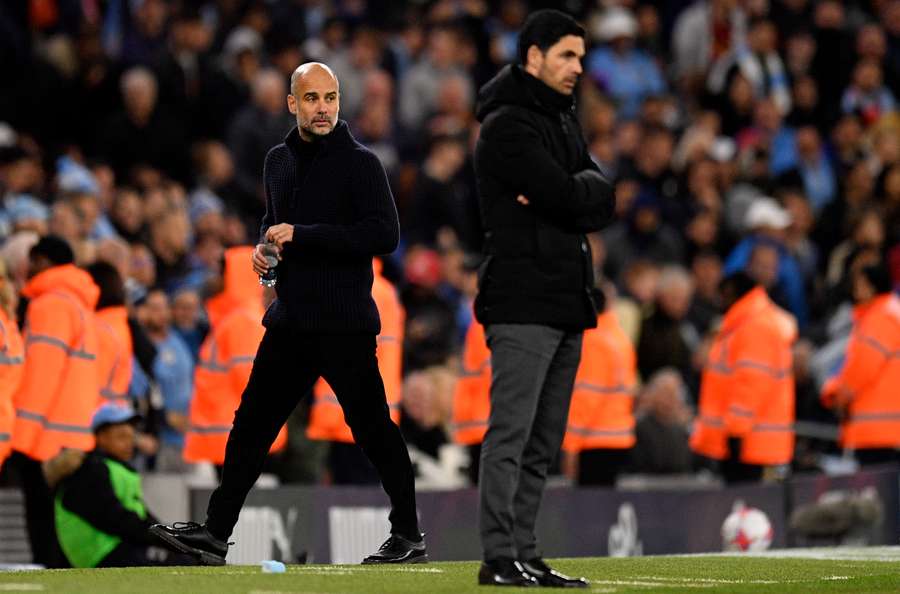 Manchester City manager Pep Guardiola (L) and Arsenal manager Mikel Arteta watch the players from the touchline during their last meeting