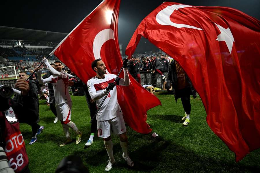 Hakan Calhanoglu (R) and Abdulkerim Bardakci fly the Turkish flag after beating Kosovo in the play-offs Hakan Calhanoglu (R) and Abdulkerim Bardakci fly the Turkish flag after beating Kosovo in the play-offs