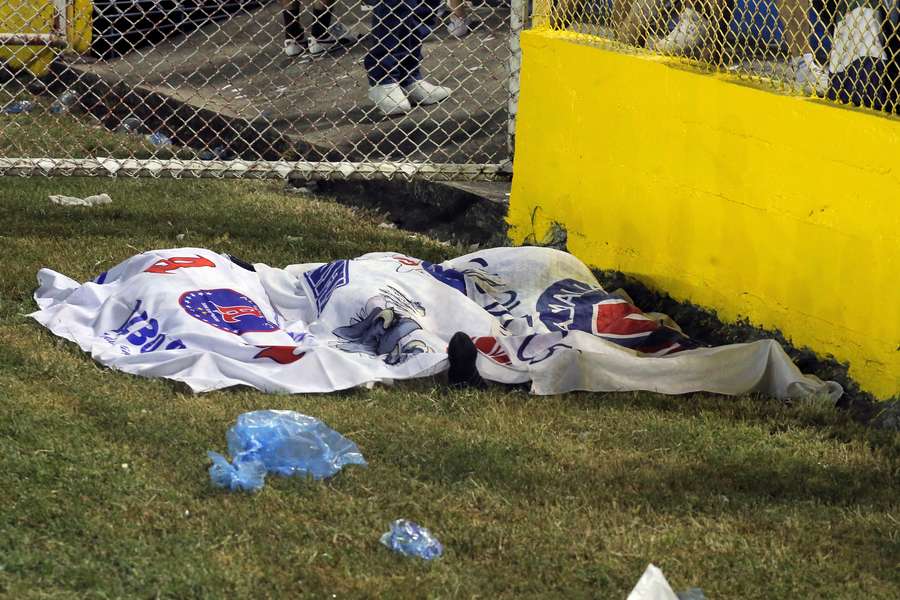 Um dos mortos, coberto com a bandeira do Alianza