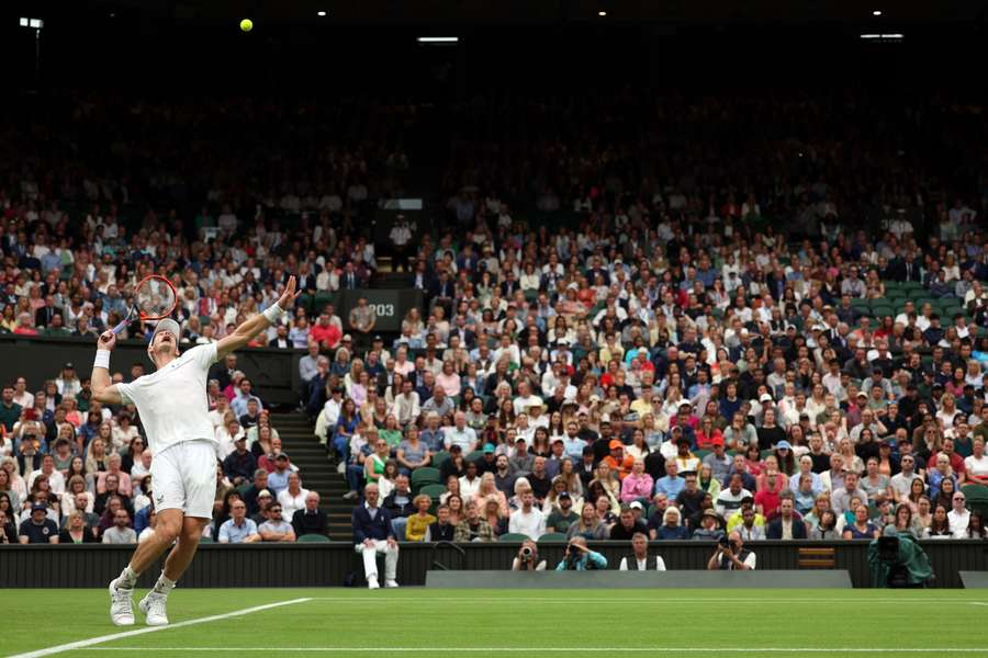 Andy Murray serves to Ryan Peniston during their first round clash on Centre Court