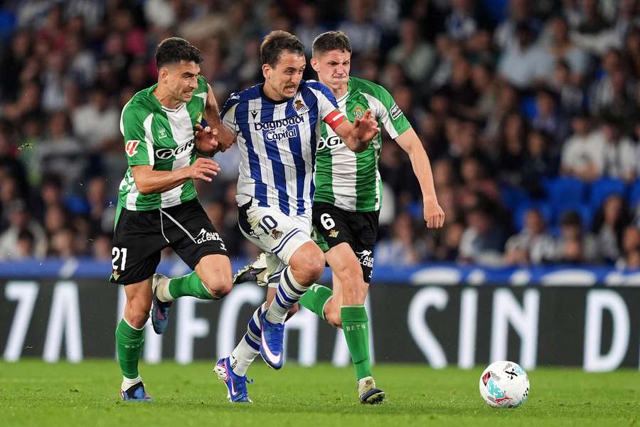 Mikel Oyarzabal of Real Sociedad is challenged by Marc Roca and Sergi Altimira of Real Betis