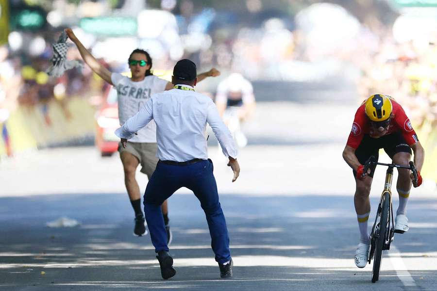 A protester runs onto the road near the finish line