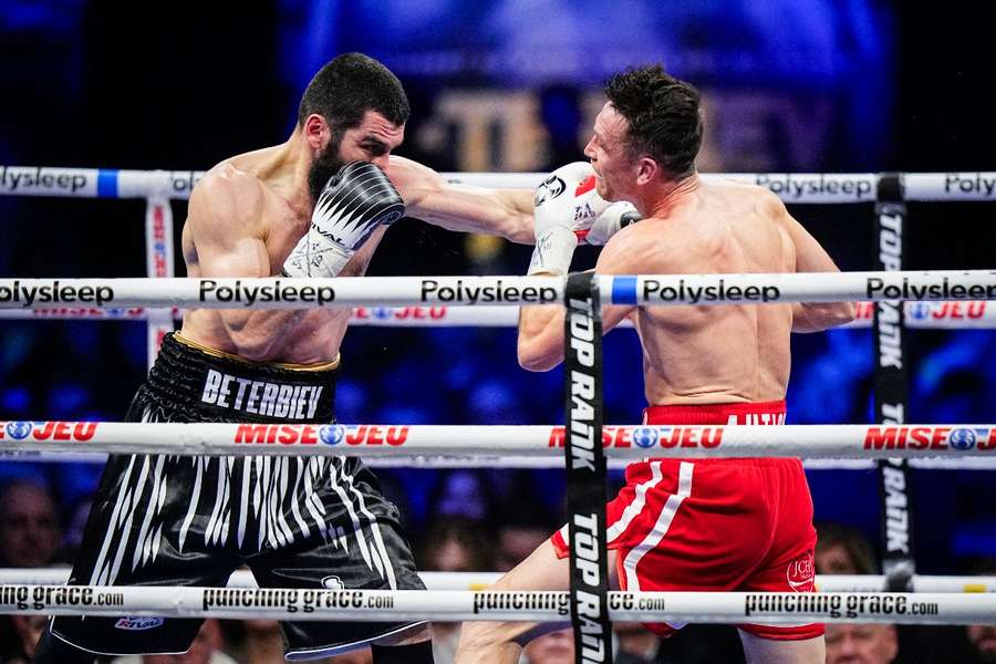 Beterbiev (L) throws a punch at Smith