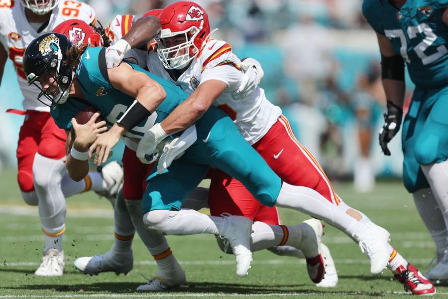 Quarterback Trevor Lawrence wordt naar de grond getackeld tegen de Chiefs