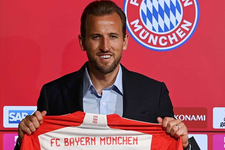 Harry Kane poses with his new number 9 shirt after signing for Bayern Munich
