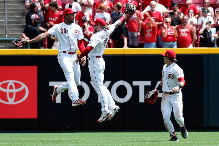 Benson, Fraley and TJ Friedl celebrate after the Reds defeated the Rockies