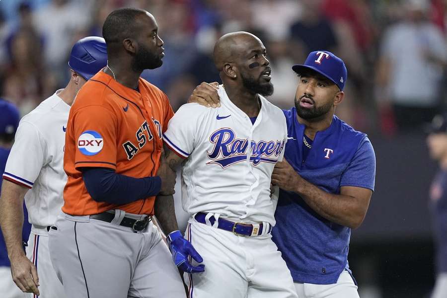 Rangers Adolis Garcia (C) is lead away by Duran (R) and Astros left fielder Alvarez (L) during a bench clearing brawl
