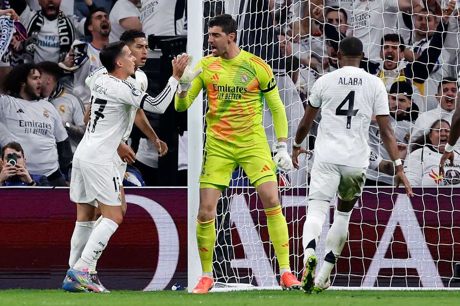 Courtois celebra con Lucas Vázquez y Bellingham el penalti parado ante Saka