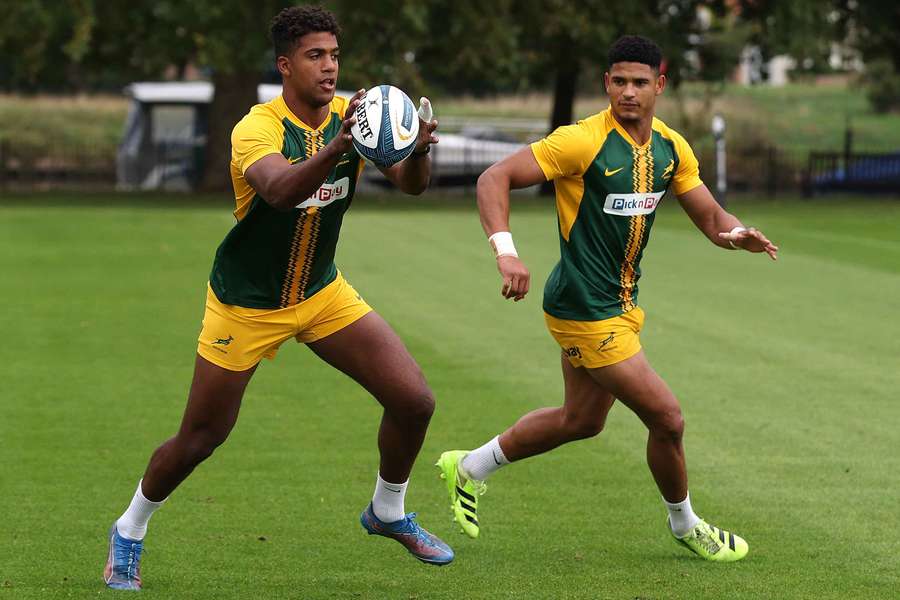 Canan Moodie and Sacha Feinberg-Mngomezulu run with the ball at a training session in Teddington, England.