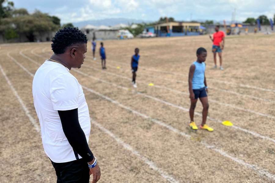 Coach Shanti Blake (L) watches children compete at the Richmond Park Sports Complex in Kingston