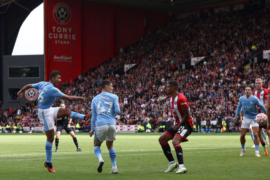 Manchester City midfielder Rodri (L) scores the go-ahead goal