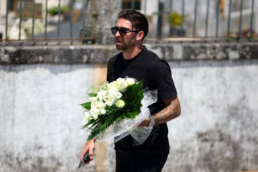 Jota Silva holds flowers as he arrives at the Chapel of the Resurrection