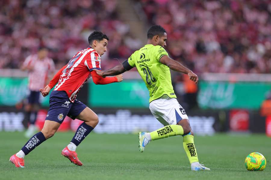 Brayan Angulo, de Puebla y Miguel Gomez de Chivas disputan un balón
