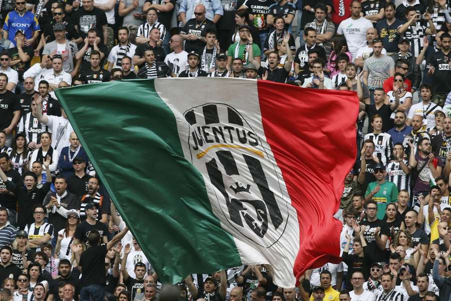 Juventus' supporters wave a giant Italian flag with the club's logo