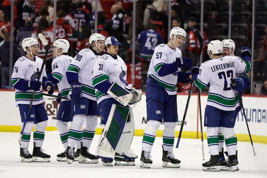 Vancouver Canucks' Jonathan Lekkerimaki is congratulated by teammates after scoring the winning goal in a shootout against the New Jersey Devils