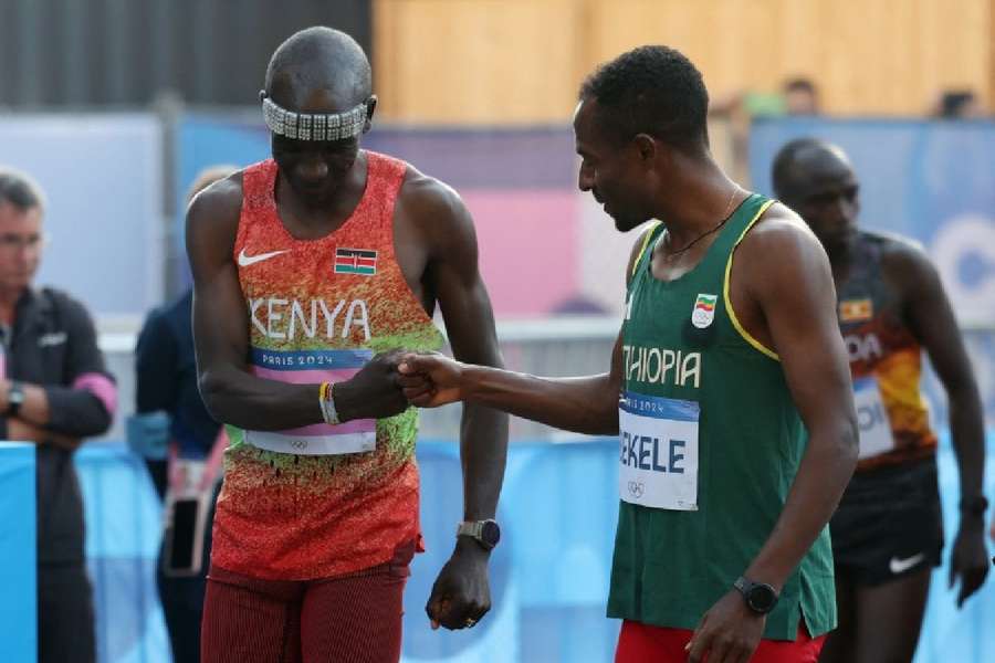 Eliud Kipchoge of Kenya bumps fists with Kenenisa Bekele of Ethiopia