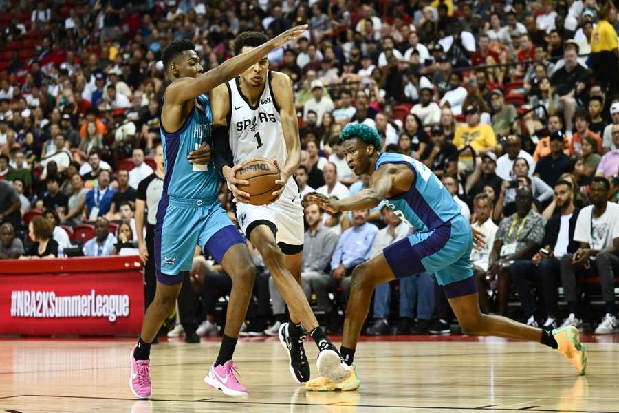 Victor Wembanyama (C), escolha número um do draft da NBA, corre com a bola