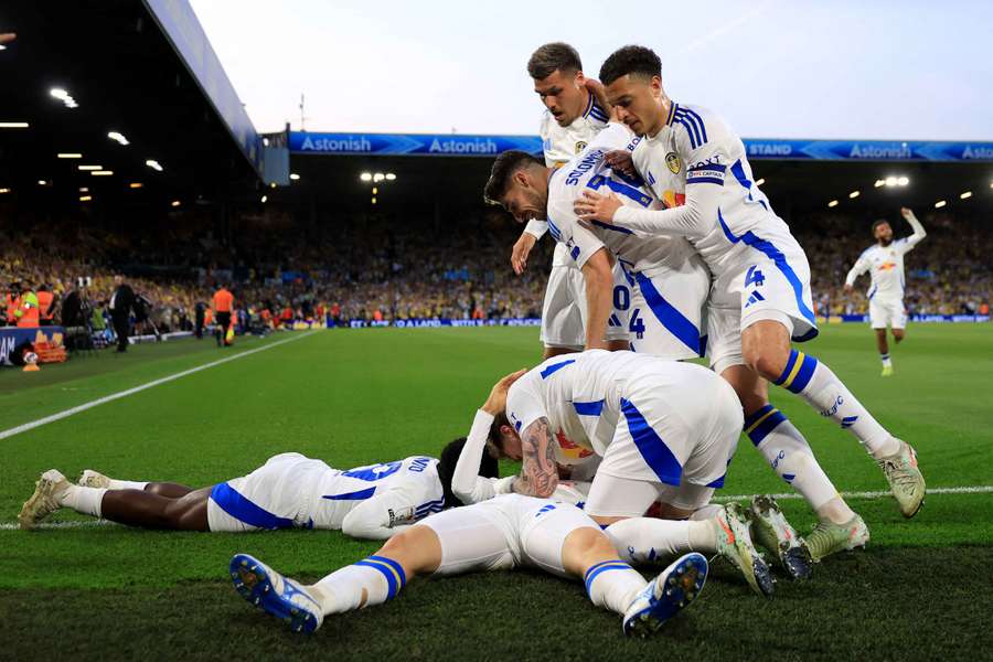 Ao Tanaka, del Leeds United (oculto en el suelo), celebra con sus compañeros el primer gol de su equipo.