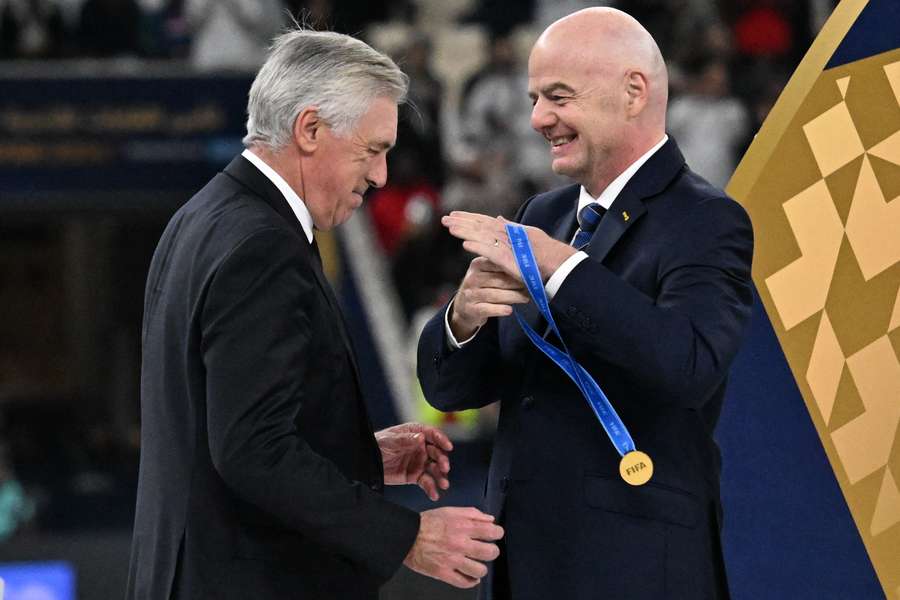 FIFA President Gianni Infantino awards Real Madrid's Italian coach Carlo Ancelotti with the gold medal after the Intercontinental Cup final