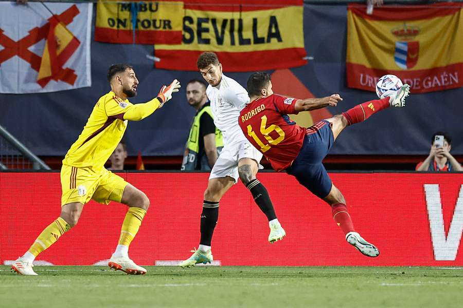 Spain midfielder Rodri (R) kicks the ball