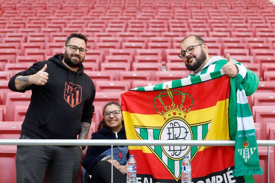 Un seguidor del Atlético junto a otro del Real Betis en la grada