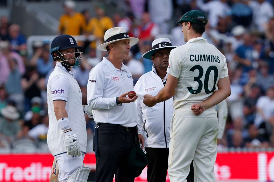Umpire Chris Gaffaney (C) explains to Australia's Pat Cummins (R) that the TV umpire Marais Erasmus has advised him that Mitchell Starc was not in control of a catch that would have dismissed England's Ben Duckett